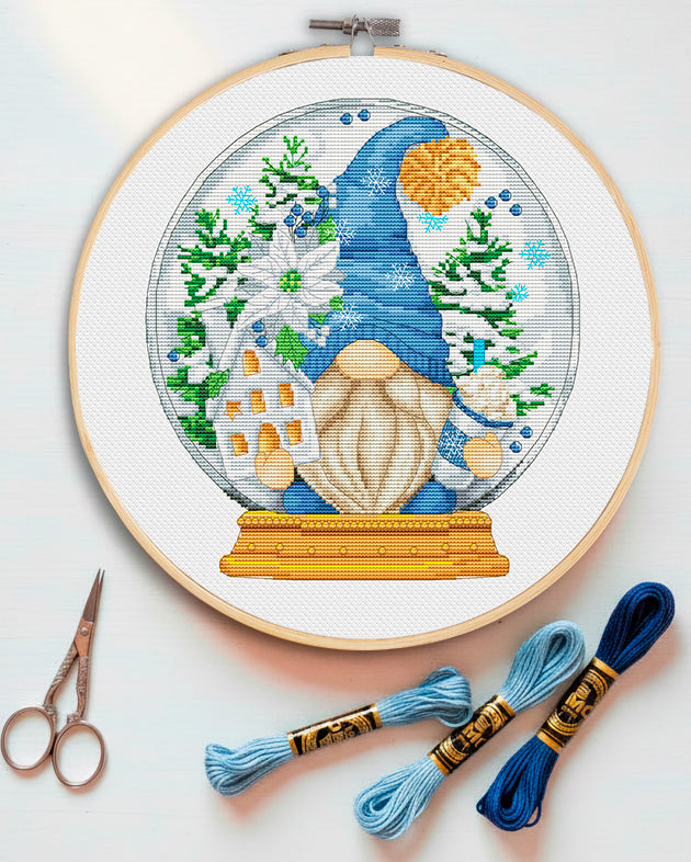 Cross stitch pattern of a "Hello Winter" Gnome with snowflakes.