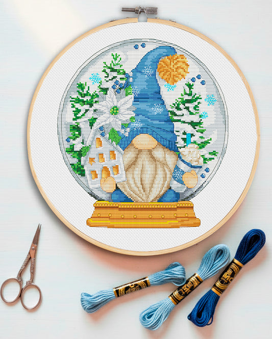 Cross stitch pattern of a "Hello Winter" Gnome with snowflakes.