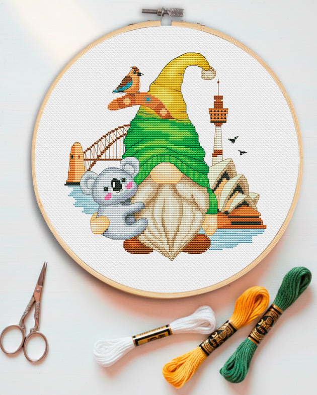 Cross stitch pattern of an Australian Gnome with a kangaroo and sun hat.