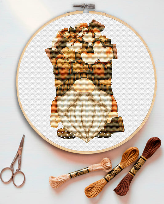 Cross stitch pattern of a S'more gnome holding a marshmallow.