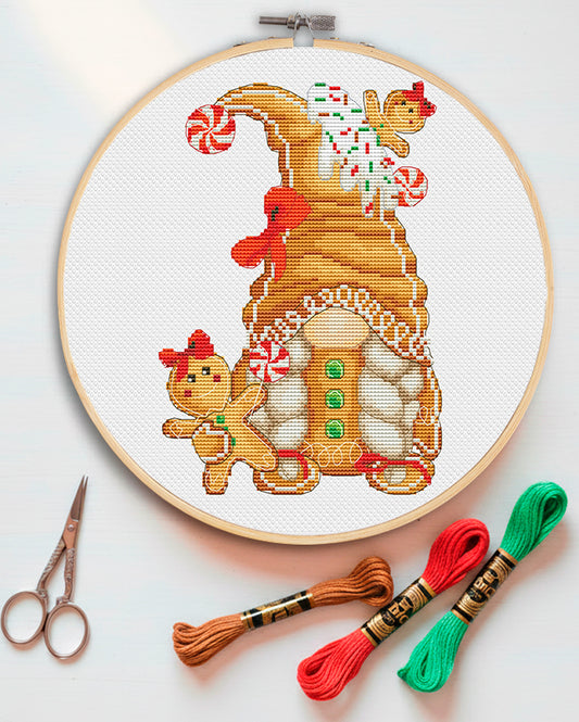 Cross stitch pattern of a Gingerbread Christmas Gnome Girl with a sweet house. 