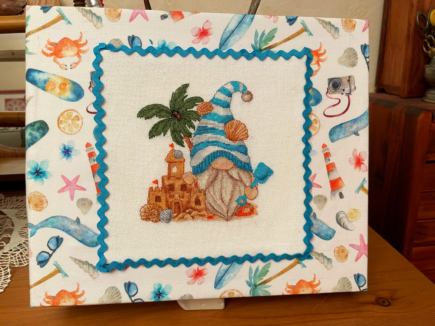 Beach gnome cross stitch finished in fabric frame with coastal themed border — CuteBroidery customer finish